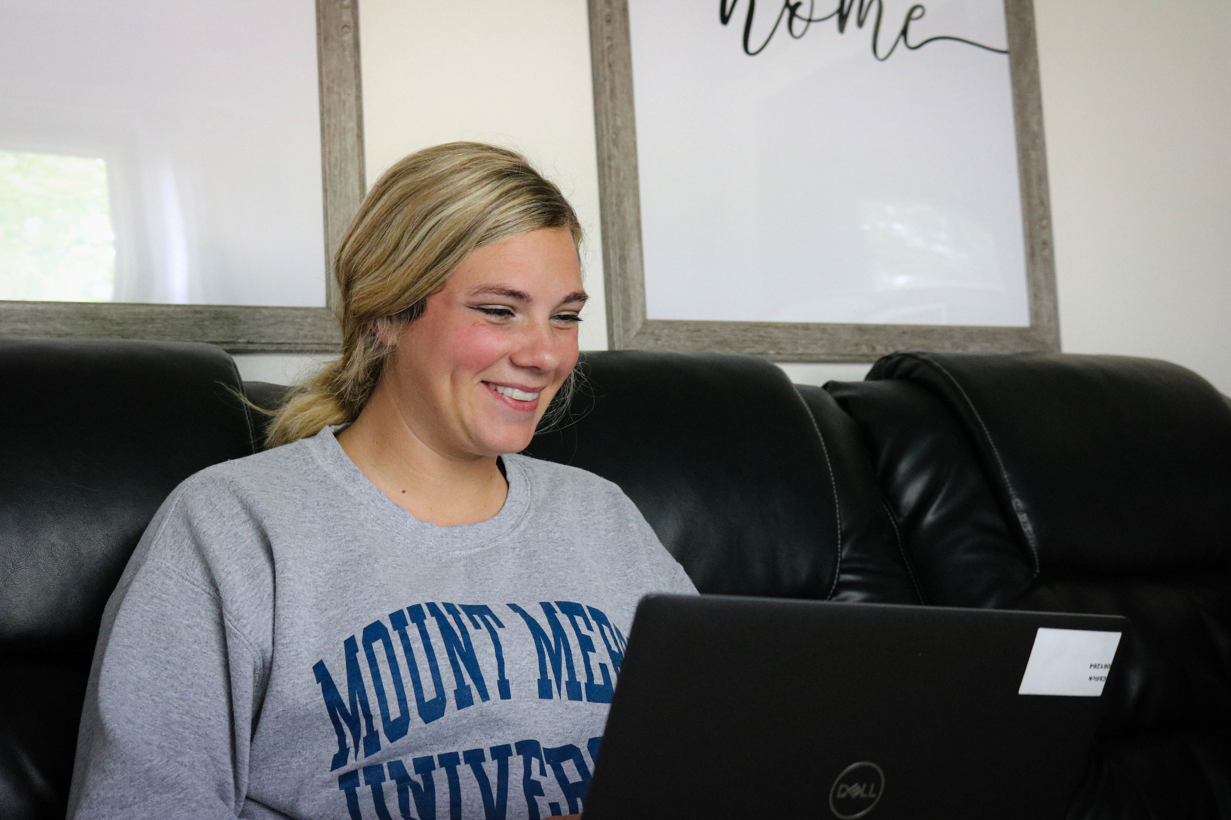 Smiling woman wearing Mount Mercy sweatshirt. mount mercy university online